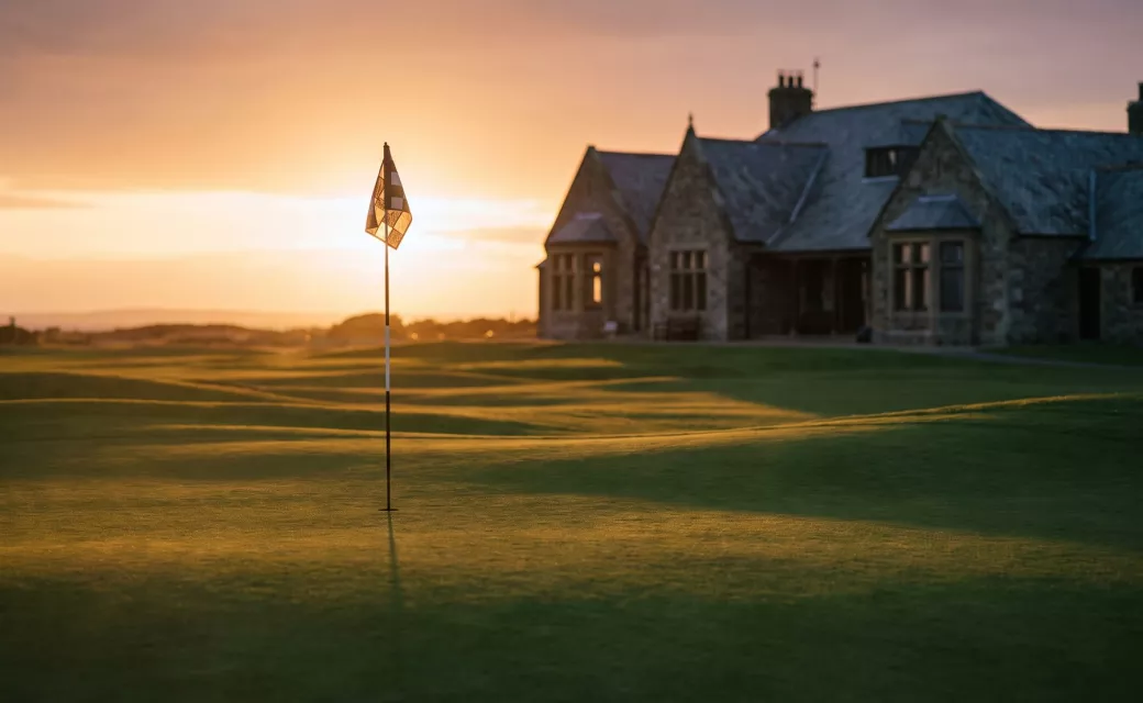 Drapeau du dernier green au coucher du soleil, club-house en arrière-plan