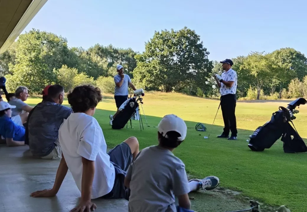 Une séance de coaching de Kevin Turlan sur un practice, les élèves assis à l’ombre